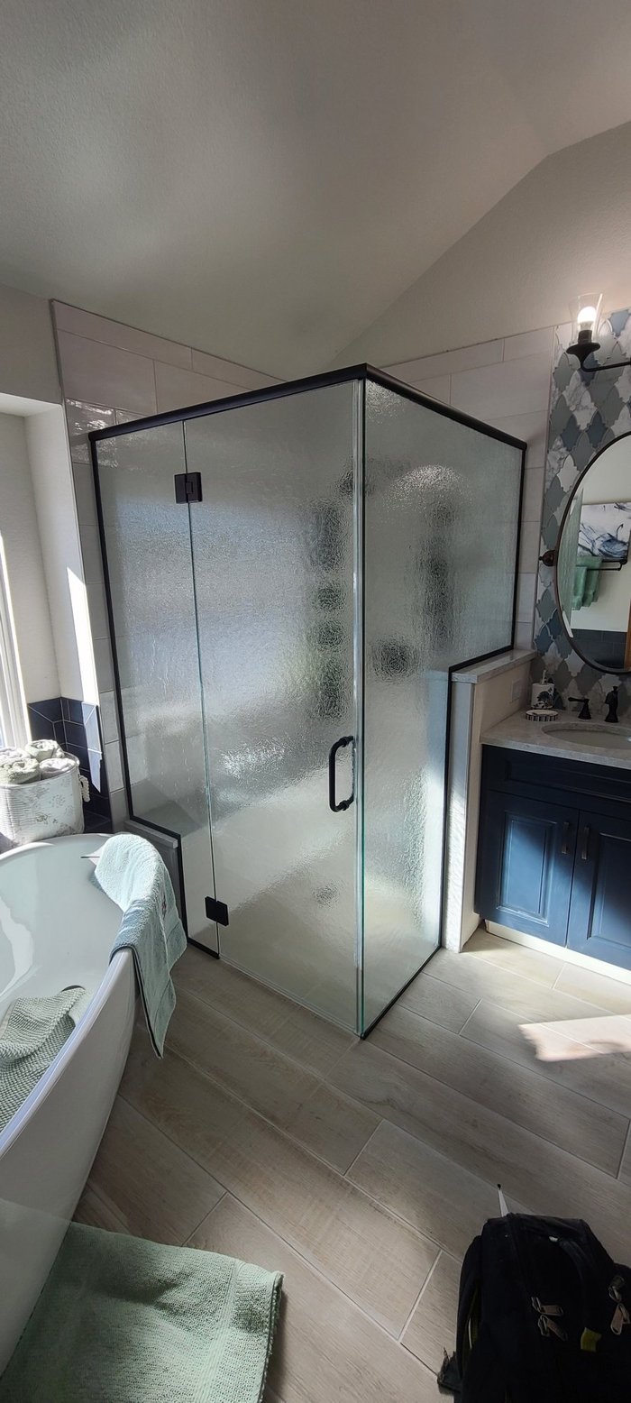 Frameless rain glass shower enclosure with matte black hardware