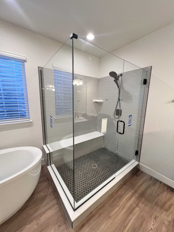 Frameless swing-door shower with inline notched return panel and matte black hardware