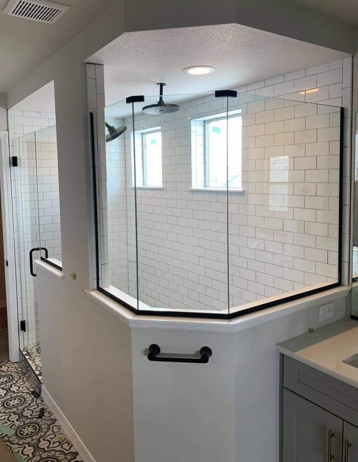 Frameless walk-in shower with matte black hardware and white subway tile