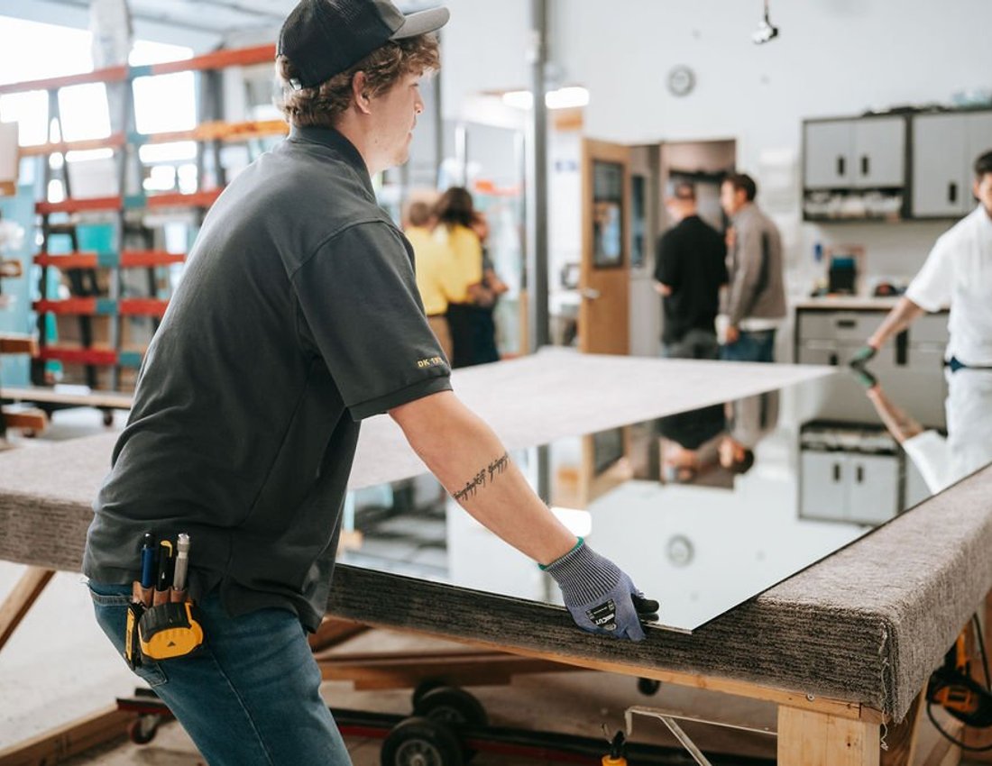 Kent Glass glazier positioning a mirror panel in the Colorado Springs fabrication shop