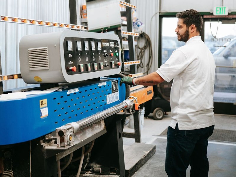 Kent Glass technician operating a glass fabrication machine